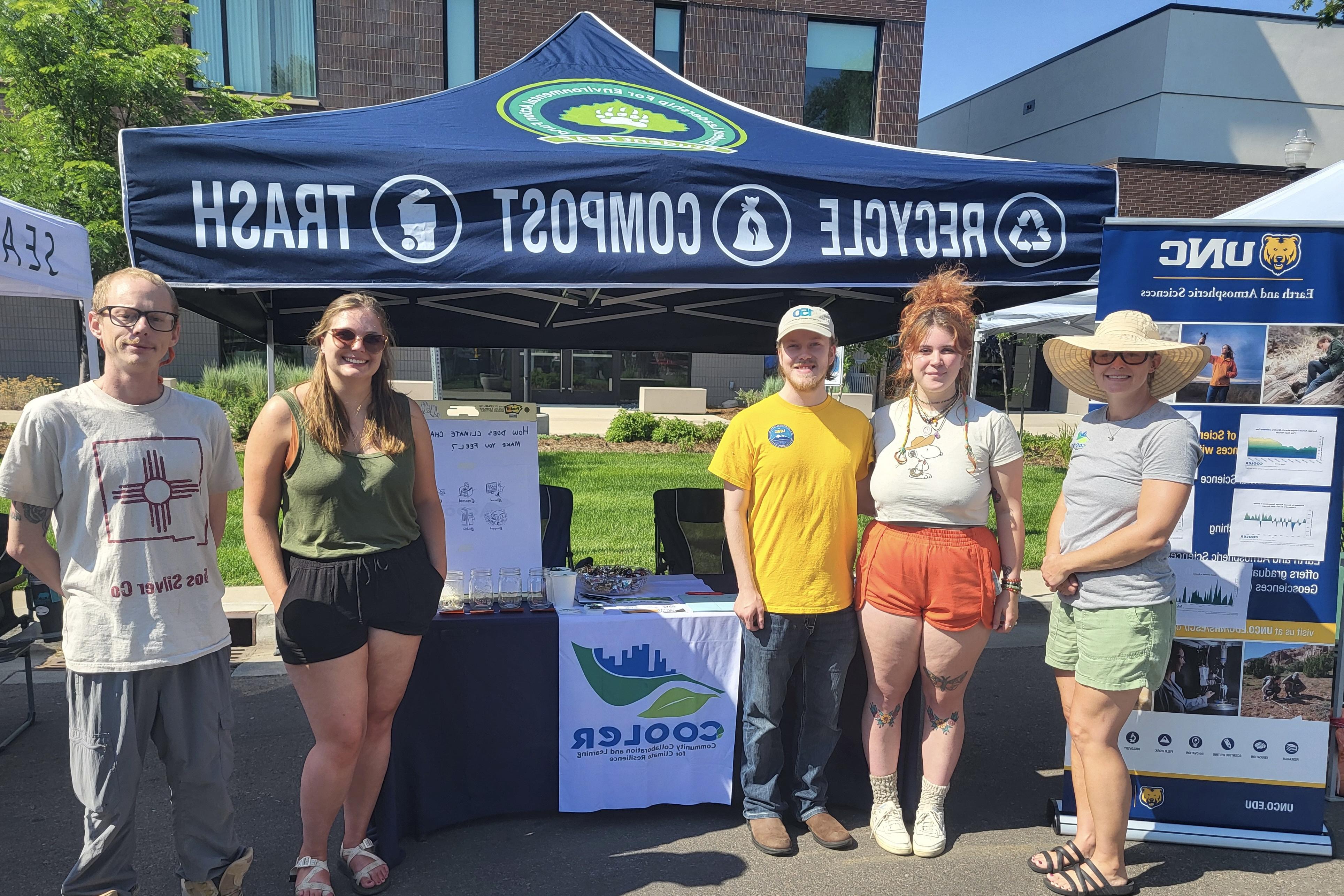 Lucinda Shellito, Sharon Bywater-Reyes, and Chelsea Romulo stand under their tent for the COOLER program.